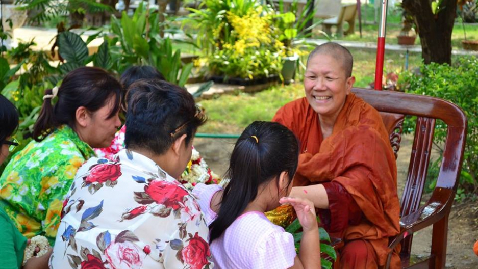 The monk Dhammanda, sitting and talking with several women