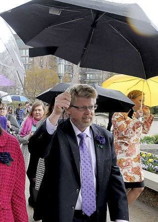 Mark Barnes holding an umbrella at the April 2014 priesthood action.